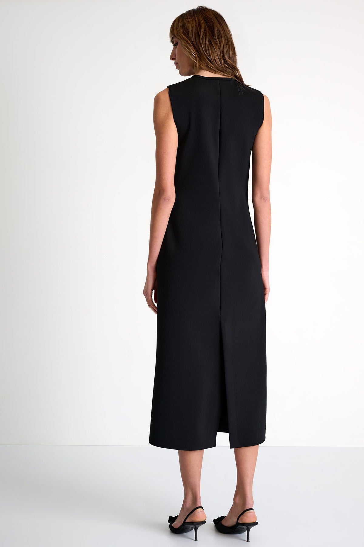 Woman wearing a black sleeveless dress on a white background
