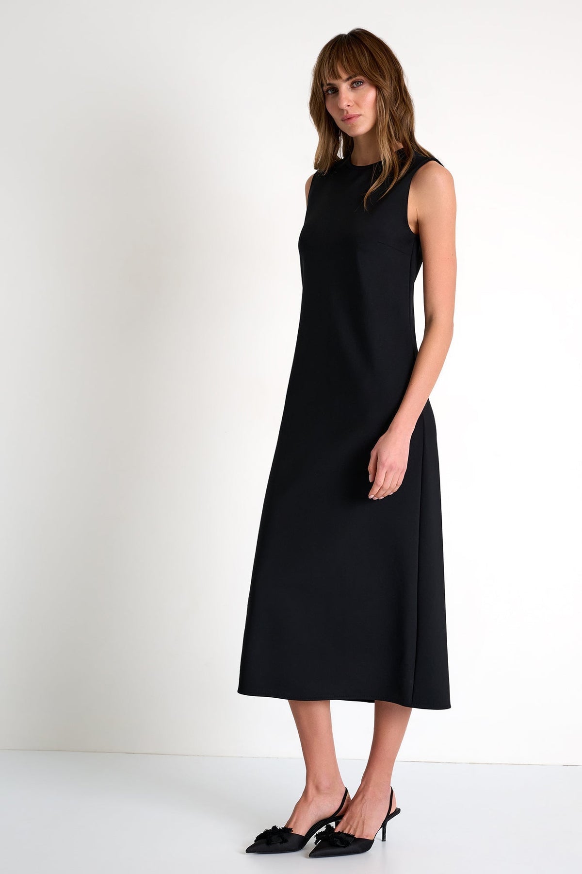 Woman wearing a black sleeveless dress on a white background