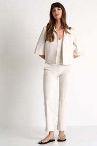 Woman wearing a white outfit on a plain background