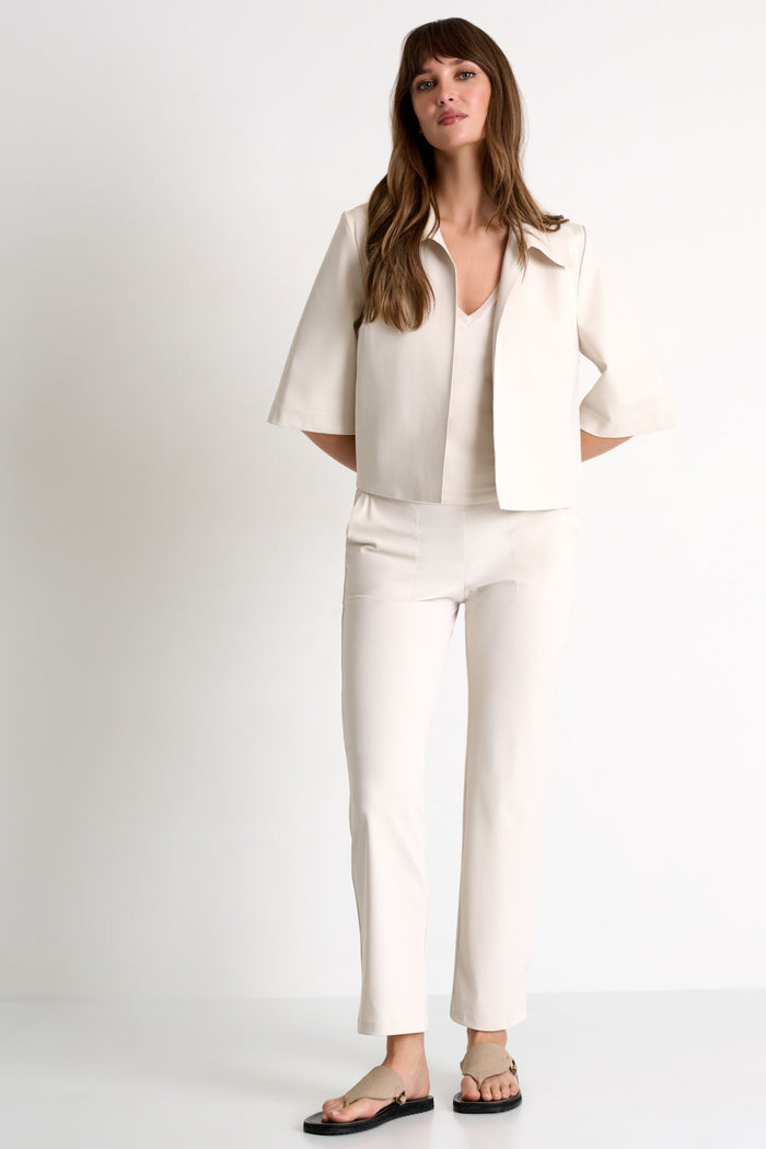 Woman wearing a white outfit on a plain background