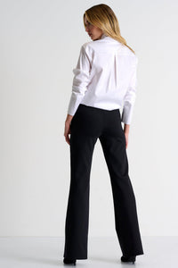 Person wearing a white sweater and black pants on a white background