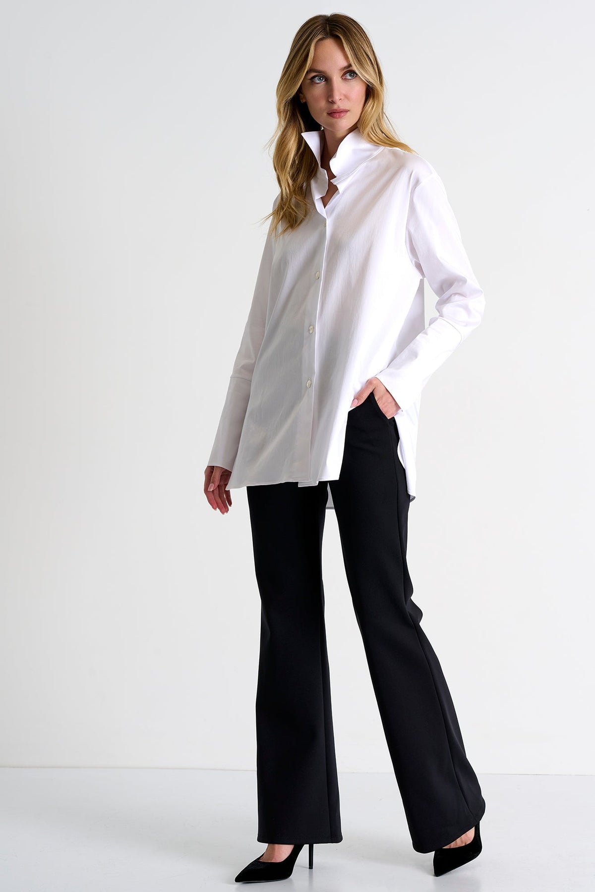 Woman wearing a white shirt and black pants on a white background