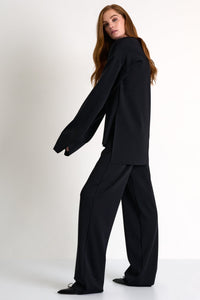 Woman wearing a black suit on a white background