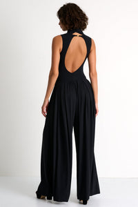 Black outfit with open back worn by a model on a white background