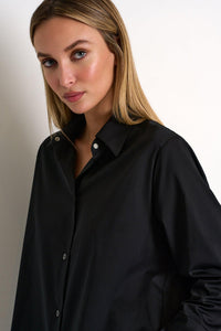 Woman wearing a black shirt against a plain background