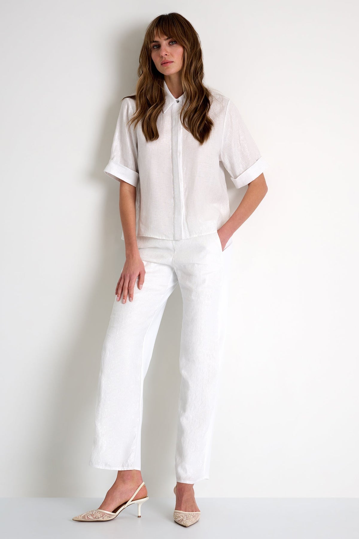 Woman wearing a white outfit on a plain background