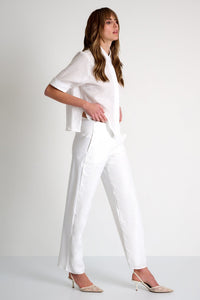 Woman wearing a white outfit on a plain background