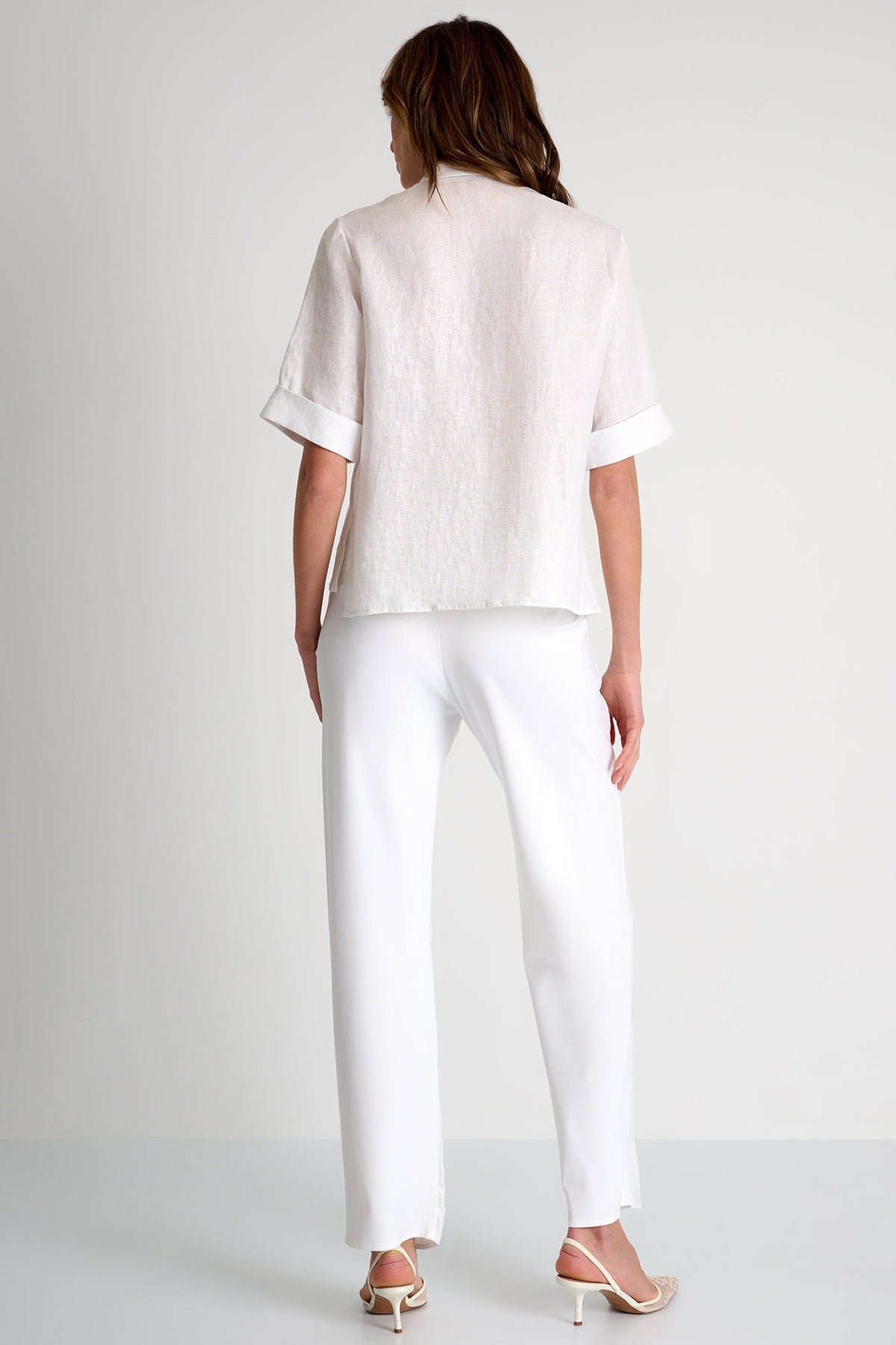 Woman wearing a white outfit on a plain background
