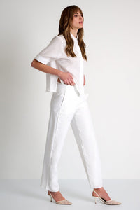 Woman wearing a white outfit on a plain background