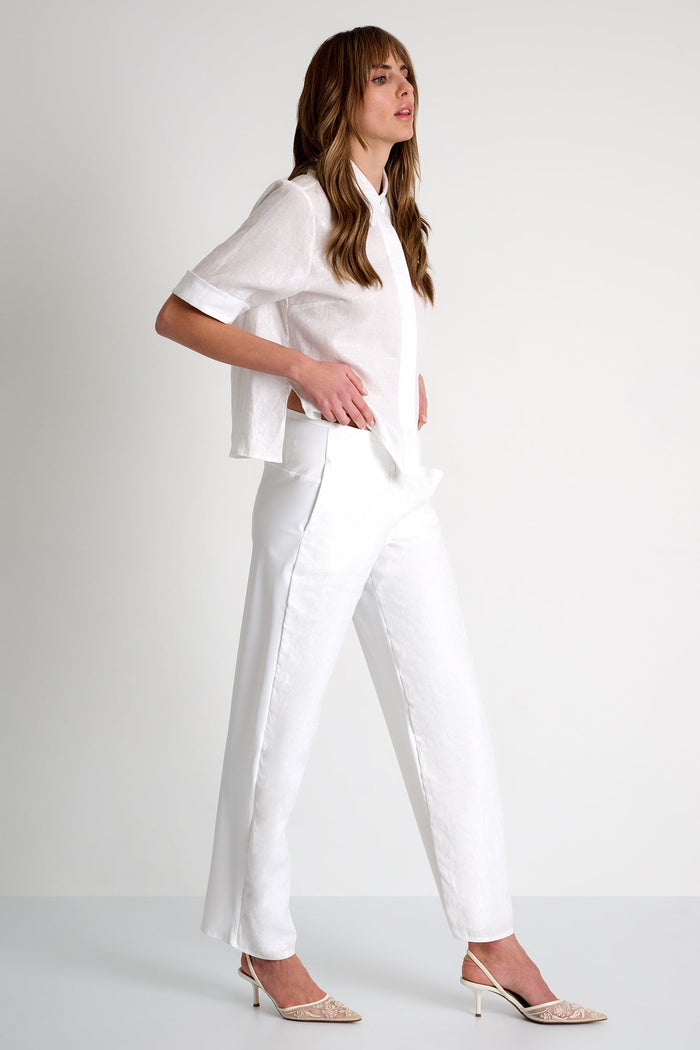 Woman wearing a white outfit on a plain background