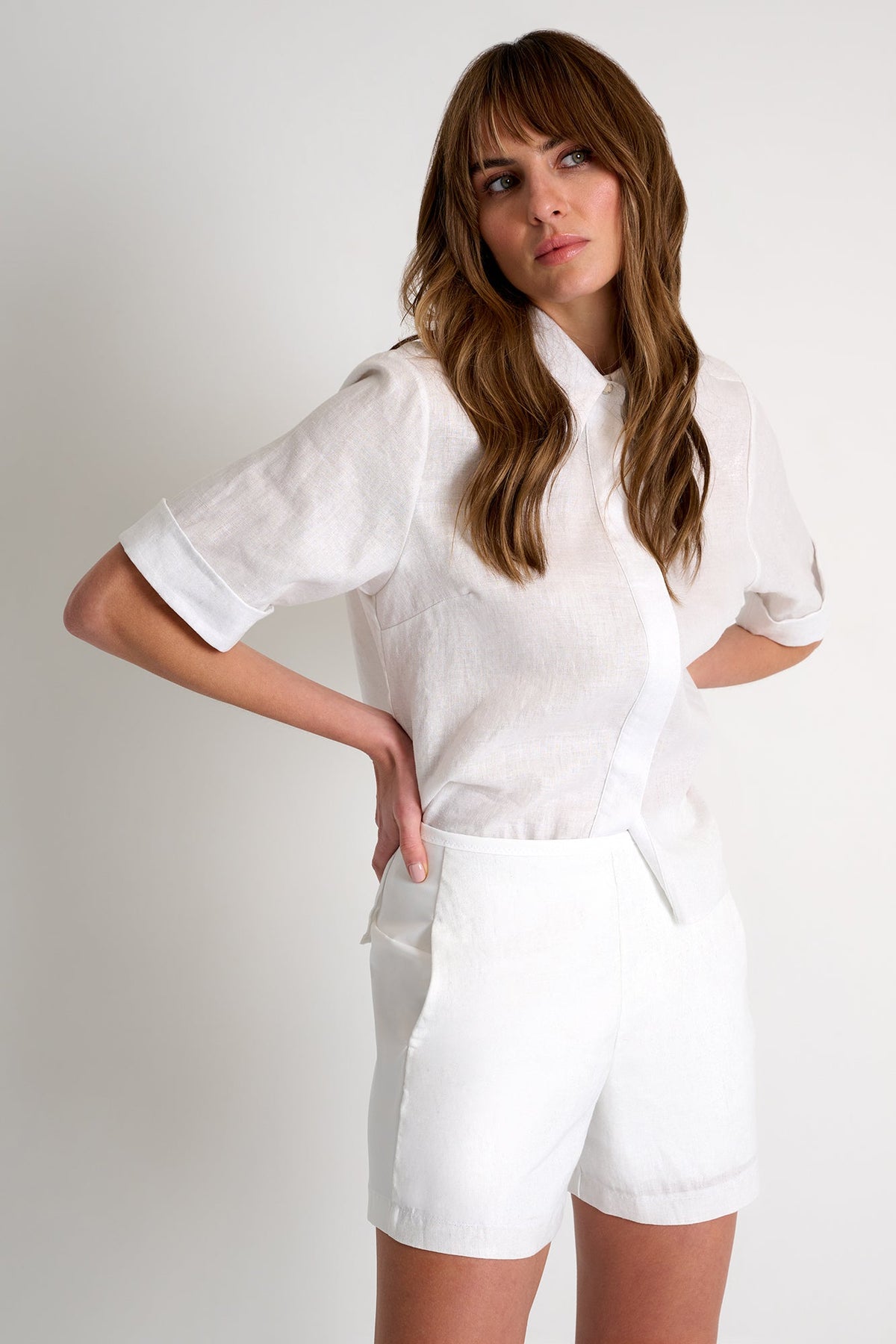 Woman wearing a white outfit with a plain background