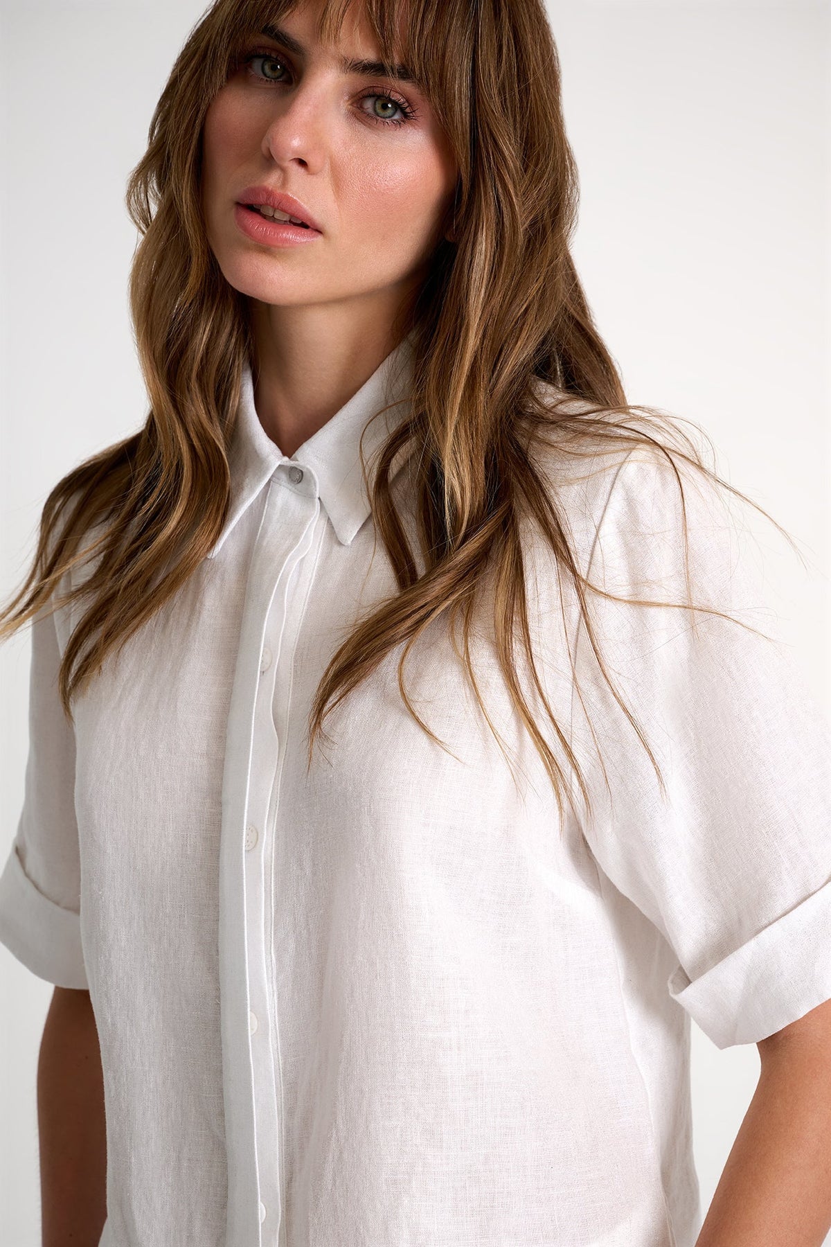 Woman wearing a white shirt against a plain background