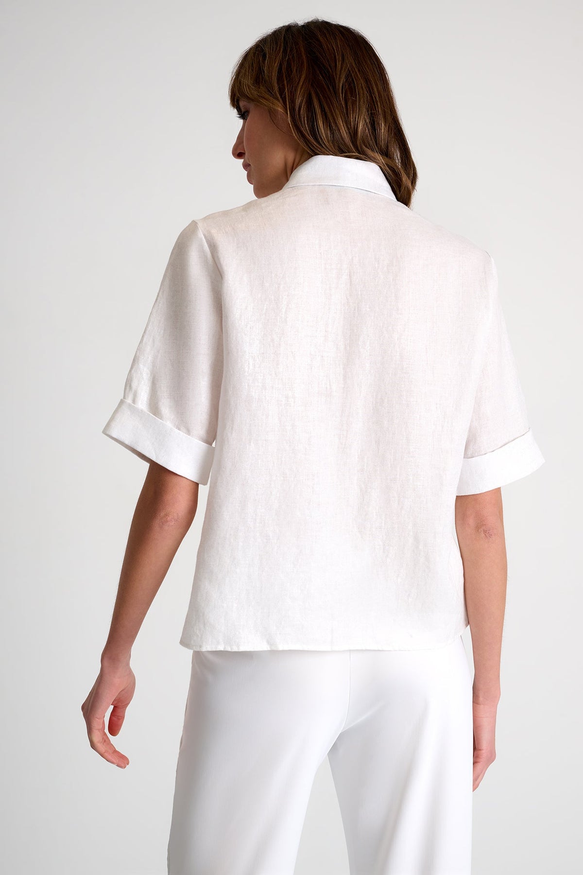 Person wearing a white outfit on a plain background